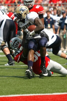 COLUMBUS, OH - SEPTEMBER 3:  Michael Brewster #50 of the Ohio State Buckeyes tackles Jawon Chisholm #44 of the Akron Zips for a loss during the third quarter on September 3, 2011 at Ohio Stadium in Columbus, Ohio. Ohio State defeated Akron 42-0. (Photo by