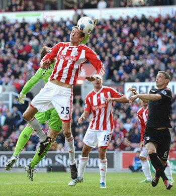 STOKE ON TRENT, ENGLAND - OCTOBER 15: Peter Crouch of Stoke rises for a header with Mark Swarzer of Fulham during the Barclays Premier League match between Stoke City and Fulham at Britannia Stadium on October 15, 2011 in Stoke on Trent, England.  (Photo 