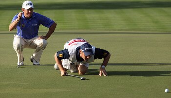 Lee Westwood and caddie read putt.