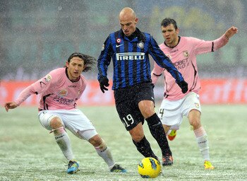 MILAN, ITALY - FEBRUARY 01:  Esteban Cambiasso (C) of Inter holds off the challenge from Edgar Barreto (L) and Nicolas Bertolo (R) of Palermo during the Serie A match between FC Internazionale Milano and US Citta di Palermo at Stadio Giuseppe Meazza on Fe