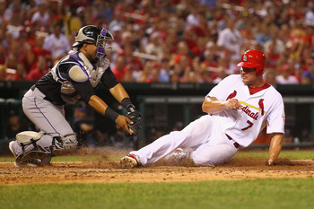 Holliday dodges a tag for a run on July 5 against the Colorado Rockies.