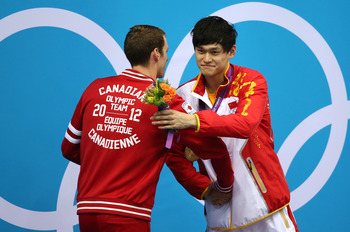 LONDON, ENGLAND - AUGUST 04:  Silver medallist Ryan Cochrane of Canada congratulates gold medallist Yang Sun of China on the podium during the medal ceremony for the Men's 1500m Freestyle Final on Day 8 of the London 2012 Olympic Games at the Aquatics Cen