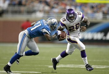 DETROIT - SEPTEMBER 20:  Running back Adrian Peterson #28 of the Minnesota Vikings carries the ball past cornerback Rhillip Buchanon #31 of the Detroit Lions at Ford Field on September 20, 2009 in Detroit, Michigan. The Vikings won 27-13.  (Photo by Steph
