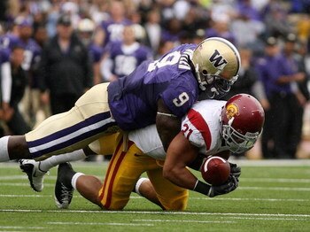 SEATTLE - SEPTEMBER 19:  Running back Stanley Havili #31 of the USC Trojans fumbles against Donald Butler #9 of the Washington Huskies in the third quarter on September 19, 2009 at Husky Stadium in Seattle, Washington. The Huskies defeated the Trojans 16-
