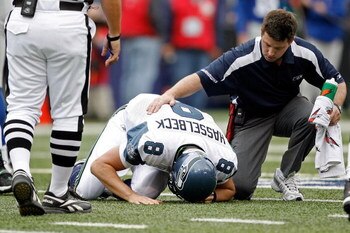 EAST RUTHERFORD, NJ - OCTOBER 05:  Quarterback Matt Hasselbeck #8 of the Seattle Seahawks is tended to by a trainer in the first half against the New York Giants at Giants Stadium on October 5, 2008 in East Rutherford, New Jersey. The Giants won 44-6.  (P