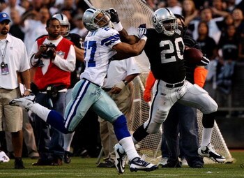 OAKLAND, CA - AUGUST 13:  Running back Darren McFadden #20 of the Oakland Raiders gives a stiff arm during a second quarter run against Courtney Brown #27 of the Dallas Cowboys during the preseason game at Oakland-Alameda County Coliseum on August 13, 200