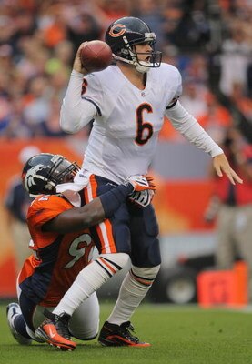 DENVER - AUGUST 30:  Quarterback Jay Cutler #6 of the Chicago Bears looks to get rid of the ball while under pressure from Elvis Dumervil #92 of the Denver Broncos during the first quarter at INVESCO Field at Mile High on August 30, 2009 in Denver, Colora