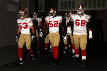 GLENDALE, AZ - SEPTEMBER 13:  (L-R) Jeff Ulbrich #53, Patrick Willis #52 and Adam Snyder #68 of the San Francisco 49ers walk out onto the field prior to the NFL game against the Arizona Cardinals at the Universtity of Phoenix Stadium on September 13, 2009
