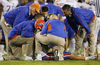 LEXINGTON, KY - SEPTEMBER 26: Quarterback Tim Tebow #15 of the Florida Gators is tended to by head coach Urban Meyer (R) and staff after Tebow was sacked by Taylor Wyndham #94 of the Kentucky Wildcats during the third quarter of the game at Commonwealth S