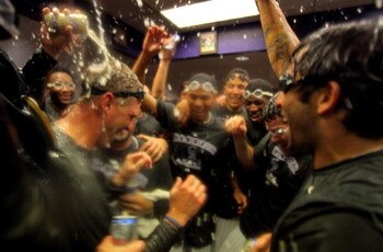 DENVER - OCTOBER 01:  Manager Jim Tracy (L) of the Colorado Rockies is showered by his teammates as they celebrate in the clubhouse after they defeated the Milwaukee Brewers 9-2 and clinched a National League playoff berth at Coors Field on October 1, 200