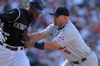 DENVER - SEPTEMBER 27:  Albert Pujols #5 of the St. Louis Cardinals gets a put out as he tags Dexter Fowler #24 of the Colorado Rockies as he lays down a sacrifice bunt at Coors Field on September 27, 2009 in Denver, Colorado. The Rockies defeated the Car