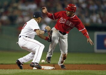 BOSTON - OCTOBER 5:  Julio Lugo #23 of the Boston Red Sox looks for the ball as Maicer Izturis #6 of the Los Angeles Angels steals second during Game 2 of the American League Division Series at Fenway Park October 5, 2007 in Boston, Massachusetts.   (Phot