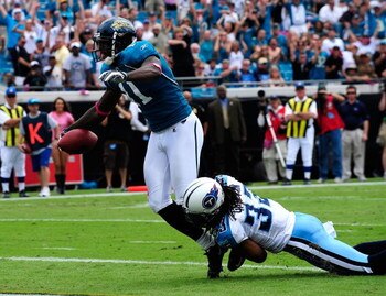 JACKSONVILLE, FL - OCTOBER 04:  Mike Sims-Walker #11 of the Jacksonville Jaguar scores a touchdown while dragging Michael Griffin #33 of the Tennessee Titans during the game at Jacksonville Municipal Stadium on October 4, 2009 in Jacksonville, Florida.  (
