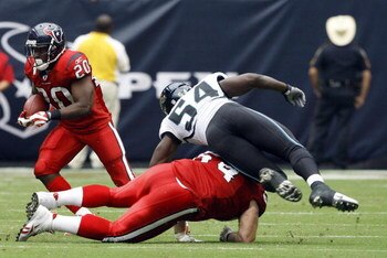 HOUSTON - SEPTEMBER 27:  Running back Steve Slaton #20 of the Houston Texans receives a block from guard Kasey Studdard #64 on  defensive end Quentin Groves #54 of the Jacksonville Jaguars at Reliant Stadium on September 27, 2009 in Houston, Texas.  (Phot