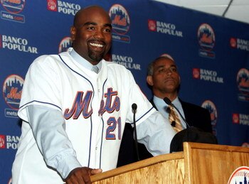 NEW YORK - NOVEMBER 28:  Carlos Delgado speaks to the media as general manager Omar Minaya looks on during the press conference introducing Delgado as the newest member of the New York Mets on November 28, 2005 at Shea Stadium in the Flushing neighborhood