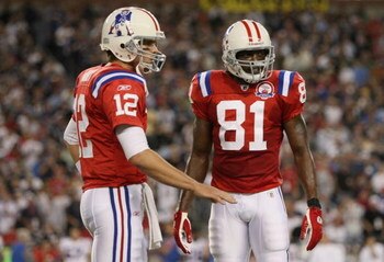 FOXBORO, MA - SEPTEMBER 14:  Quarterback Tom Brady #12 of the New England Patriots speaks to wide receiver Randy Moss #81 during the second quarter against the Buffalo Bills on September 14, 2009 at Gillette Stadium in Foxboro, Massachusetts. (Photo by Ji