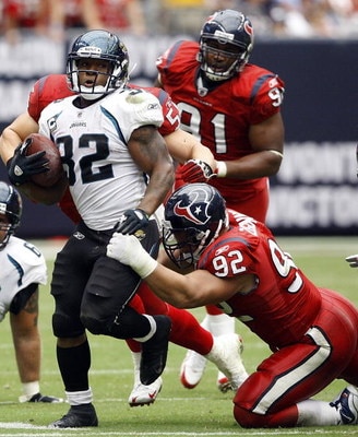 HOUSTON - SEPTEMBER 27:  Running back Maurice Jones-Drew #32 of the Jacksonville jaguars rushes for yardage in the fourth quarter as defensive tackle Jeff Zgonina #92 of the Houston Texans makes the tackle during the game at Reliant Stadium on September 2