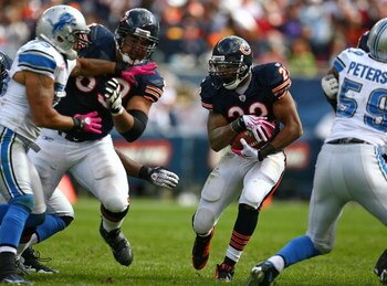 CHICAGO - OCTOBER 04: Matt Forte #22 of the Chicago Bears looks for running room as teammate Roberto Garza #63 blocks Larry Foote #55 of the Detroit Lions on October 4, 2009 at Soldier Field in Chicago, Illinois. The Bears defeated the Lions 48-24. (Photo