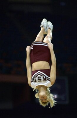 NEW ORLEANS - MARCH 15:  A Mississippi State cheerleader is flipped into the air during semifinal action in the SEC Men's Basketball Tournament against Louisiana State Univerity at the Louisiana Superdome on March 15, 2003 in New Orleans, Louisiana. Missi