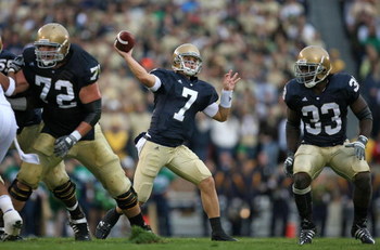 SOUTH BEND, IN - OCTOBER 03: Jimmy Clausen #7 of the Notre Dame Fighting Irish passes the ball as teammates Paul Duncan #72 and Robert Hughes #33 look to block against the Washington Huskies on October 3, 2009 at Notre Dame Stadium in South Bend, Indiana.