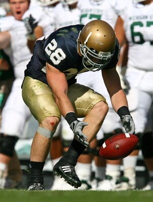 SOUTH BEND, IN - SEPTEMBER 19: Kyle McCarthy #28 of the Notre Dame Fighting Irish tries to pick up a loose ball against the Michigan State Spartans on September 19, 2009 at Notre Dame Stadium in South Bend, Indiana. Notre Dame defeated Michigan State 33-3