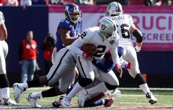 EAST RUTHERFORD, NJ - OCTOBER 11:  JaMarcus Russell #2 of the Oakland Raiders is sacked by Michael Johnson #20 of the New York Giants on October 11, 2009 at Giants Stadium in East Rutherford, New Jersey.  (Photo by Jim McIsaac/Getty Images)