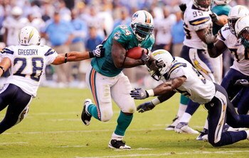 SAN DIEGO - SEPTEMBER 27:  Ricky Williams #34 of the Miami Dolphins runs away from tacklers on his way to score a touchdown against Steve Gregory #28 of the San Diego Chargers during fourth quarter of the NFL football game at Qualcomm Stadium on September