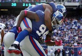 EAST RUTHERFORD, NJ - OCTOBER 11:  Mathias Kiwanuka #94 of the New York Giants celebrates after forcing a fumble against the Oakland Raiders with teammate Osi Umenyiora #72 on October 11, 2009 at Giants Stadium in East Rutherford, New Jersey. The Giants d