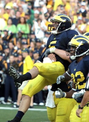 ANN ARBOR, MI - SEPTEMBER 12:  Quarterback Tate Forcier #5 of Michigan is hugged by a teammate after scoring a touchdown late in the game against Notre Dame at Michigan Stadium on September 12, 2009 in Ann Arbor, Michigan.  (Photo by Domenic Centofanti/Ge