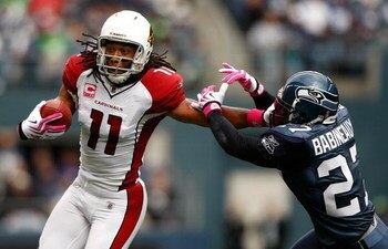 SEATTLE, WA - OCTOBER 18:  Larry Fitzgerald #11 of the Arizona Cardinals breaks a tackle by Jordan Babineaux #27 of the Seattle Seahawks at Qwest Field on October 18, 2009 in Seattle, Washington.  (Photo by Jonathan Ferrey/Getty Images)