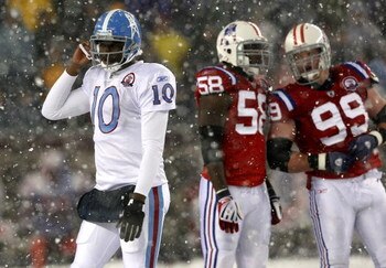 FOXBORO - OCTOBER 18:  Vince Young #10 of the Tennessee Titans leaves the field as Pierre Woods #58 and Mike Wright #99 of the New England Patriots converse at Gillette Stadium on October 18, 2009 in Foxboro, Massachusetts. The Patriots won 59-0. (Photo b