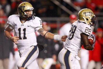 PISCATAWAY, NJ - OCTOBER 16: Bill Stull #11 hands the ball off to Dion Lewis #28 of the University of Pittsburgh Panthers against the Rutgers University Scarlett Knights on October 16, 2009 at Rutgers Stadium in Piscataway, New Jersey.  (Photo by Jared Wi