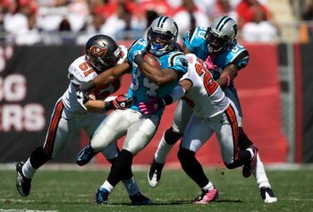 TAMPA, FL - OCTOBER 18:  Running back DeAngelo Williams #34 of the Carolina Panthers is tackled by defenders Barrett Ruud #51 and Ronde Barber #20 of the Tampa Bay Buccaneers during the game at Raymond James Stadium on October 18, 2009 in Tampa, Florida. 
