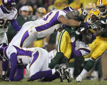 GREEN BAY, WI - DECEMBER 21:  Donald Driver #80 of the Green Bay Packers fights for yardage as he is tackled by Kevin Williams #93 and Dwight Smith #24 of the Minnesota Vikings on December 21, 2006 at Lambeau Field in Green Bay, Wisconsin. (Photo by Jonat