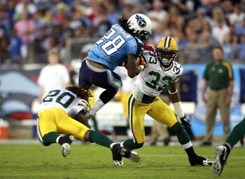 NASHVILLE, TN - SEPTEMBER 3: Chris Johnson #28 of the Tennessee Titans attempts to jump over defenders Atari Bigby #20 and Brandon Underwood #33 of the Green Bay Packers during a preseason NFL game at LP Field on September 3, 2009 in Nashville, Tennessee.