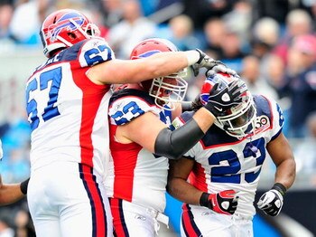 CHARLOTTE, NC - OCTOBER 25:  Andy Levitre #67, Geoff Hangartner #63 and Marshawn Lynch #23 of the Buffalo Bills during celebrate Lynch's touchdown against the Carolina Panthers at Bank of America Stadium on October 25, 2009 in Charlotte, North Carolina.  