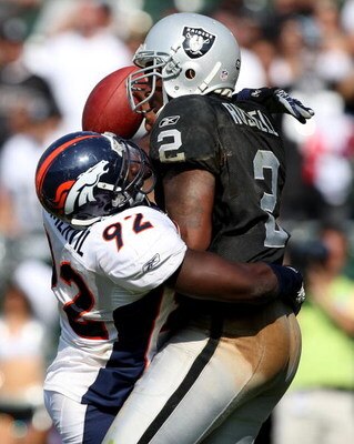 OAKLAND, CA - SEPTEMBER 27:  JaMarcus Russell #2 of the Oakland Raiders is sacked by Elvis Dumervil #92 of the Denver Broncos on September 27, 2009 during an NFL game at the Oakland-Alameda County Coliseum in Oakland, California.  (Photo by Jed Jacobsohn/