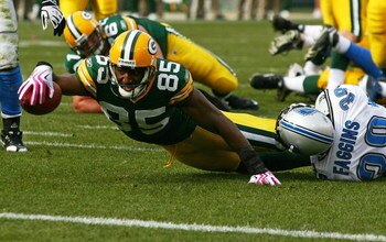GREEN BAY, WI - OCTOBER 18: Greg Jennings #85 of the Green Bay Packers stretches to reach the goal line as he's tackled by Demarcus Faggins #38 of the Detroit Lions at Lambeau Field on October 18, 2009 in Green Bay, Wisconsin. The Packers defeated the Lio
