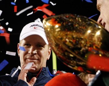 LAS VEGAS - DECEMBER 20:  Head coach Mike Stoops of the Arizona Wildcats is presented with a trophy after defeating the Brigham Young University Cougars 31-21 in the Pioneer Las Vegas Bowl at Sam Boyd Stadium December 20, 2008 in Las Vegas, Nevada.  (Phot