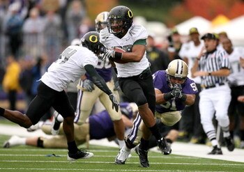 SEATTLE - OCTOBER 24:  Linebacker Kenny Rowe #58 of the Oregon Ducks returns an interception against Mykenna Ikehara #51 of the Washington Huskies on October 24, 2009 at Husky Stadium in Seattle, Washington. The Ducks defeated the Huskies 43-19. (Photo by
