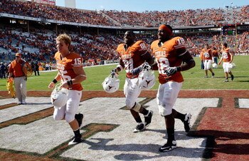 DALLAS - OCTOBER 17:  Hunter Lawrence #15, Sam Acho #81 and Emmanuel Acho #18 of the Texas Longhorns run off the field after a win against the Oklahoma Sooners at Cotton Bowl on October 17, 2009 in Dallas, Texas.  (Photo by Ronald Martinez/Getty Images)