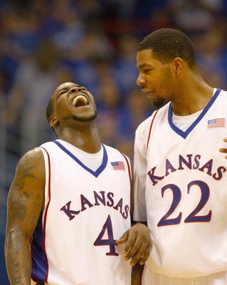 LAWRENCE, KANSAS - JANUARY 3:  Sherron Collins #4 of the Kansas Jayhawks laughs with Marcus Morris #22 against the Tennessee Volunteers on January 3, 2009 at Allen Fieldhouse in Lawrence, Kansas. (Photo by: Jamie Squire/Getty Images)