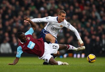 LONDON - FEBRUARY 08:  Nemanja Vidic of Manchester United challenges Carlton Cole of West Ham United  during the Barclays Premier League match between West Ham United and Manchester United at Upton Park on February 8, 2009 in London, England.  (Photo by R