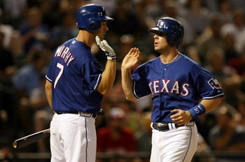 ARLINGTON, TX - JULY 11:  Michael Young #10 of the Texas Rangers celebrates scoring a run with David Murphy #7 during action against the Chicago White Sox in the 6th inning on July 11, 2008 at Rangers Ballpark in Arlington, Texas.  (Photo by Ronald Martin