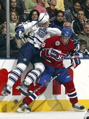 TORONTO - NOVEMBER 11:   Alexei Ponikarovsky #23 of the Toronto Maple Leafs checks Mike Komisarek #8 of the Montreal Canadiens during their NHL game at the Air Canada Centre on November 11, 2006 in Toronto, Ontario. The Leafs beat the Canadiens 5-1.  (Pho