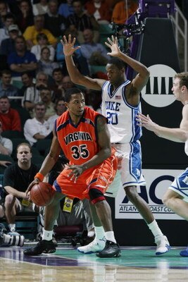 GREENSBORO, NC - MARCH 14:  Travis Watson #35 of the University of Virginia Cavaliers moves the ball under the basket while being guarded by center Casey Sanders #20 of the Duke University Blue Devils during a quarter final game of the ACC Tournament on M