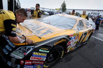 LONG POND, PA - AUGUST 03: Crew members cover the car of Matt Kenseth, driver of the #17 DeWalt Ford, in the rain before qualifying for the NASCAR Nextel Cup Series Pennsylvania 500 at Pocono Raceway on August 3, 2007 in Long Pond, Pennsylvania.  (Photo b