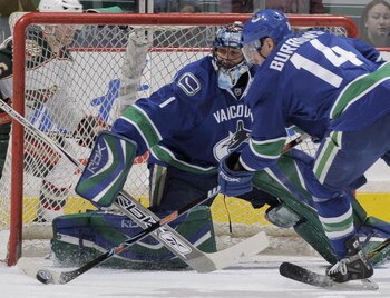 VANCOUVER, CANADA - MARCH 17:  Left wing Alex Burrows #14 of the Vancouver Canucks clears the puck from infront of goalie Roberto Luongo #1 of the Vancouver Canucks during their game against the Minnesota Wild at General Motors Place on March 21, 2008 in 