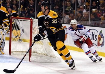 BOSTON - JANUARY 31:  Zdeno Chara #33 of the Boston Bruins tries to keep the puck from Scott Gomez #19 of the New York Rangers on January 31, 2009 at the TD Banknorth Garden in Boston, Massachusetts.  (Photo by Elsa/Getty Images)
