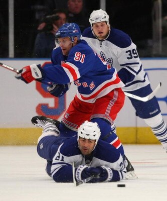 NEW YORK - FEBRUARY 22: Jamal Mayers #21 of the Toronto Maple Leafs is tripped up by Markus Naslund #91 of the New York Rangers on February 22, 2009 at Madison Square Garden in New York City. (Photo by Bruce Bennett/Getty Images)